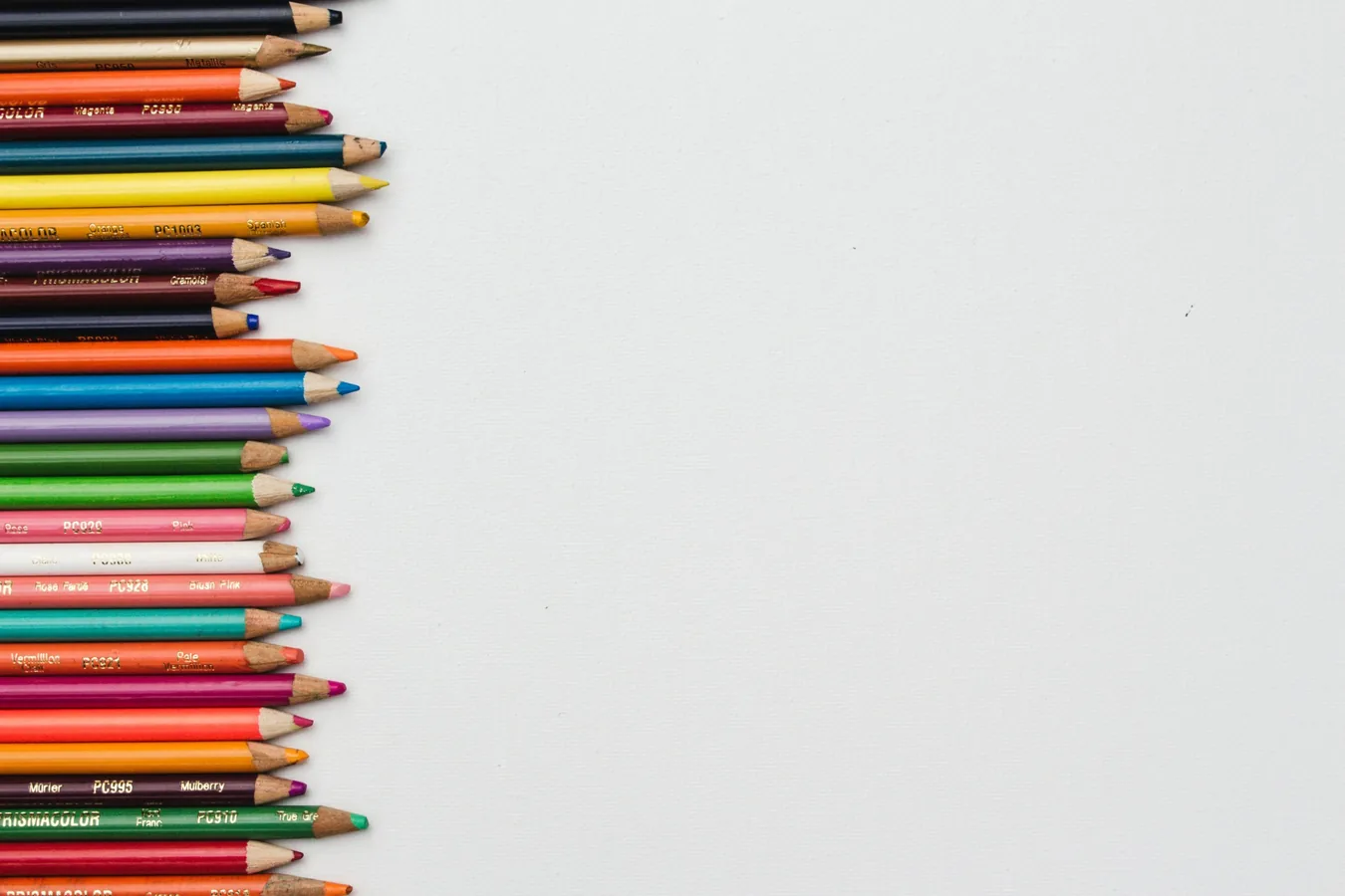 Colorful pencils arranged beside a clean white workspace